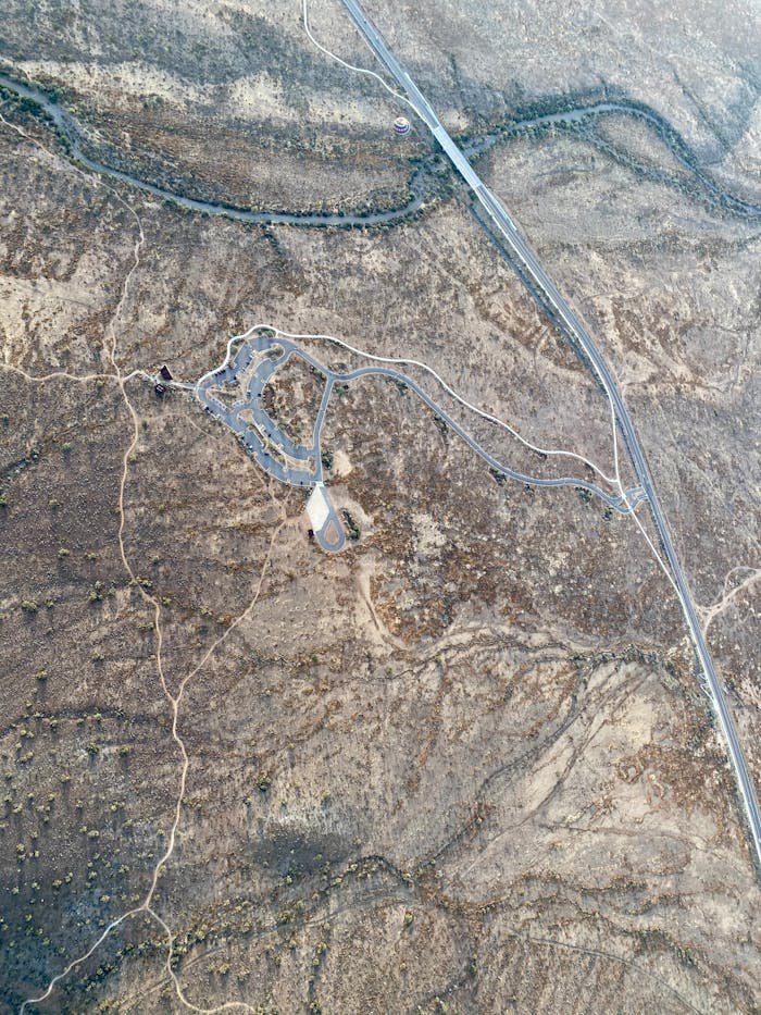A captivating aerial shot showcasing winding roads and natural patterns in a desert landscape.